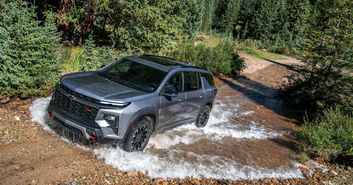 a 2026 chevy traverse driving up a hill through water