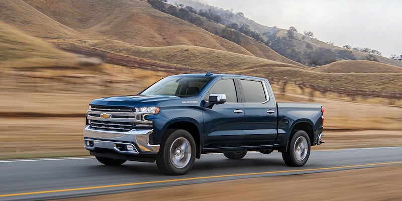 A dark blue Chevrolet Silverado 1500 driving in the hills