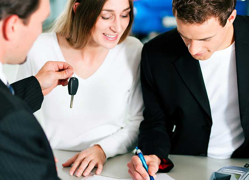 A couple signing a lease to their new vehicle